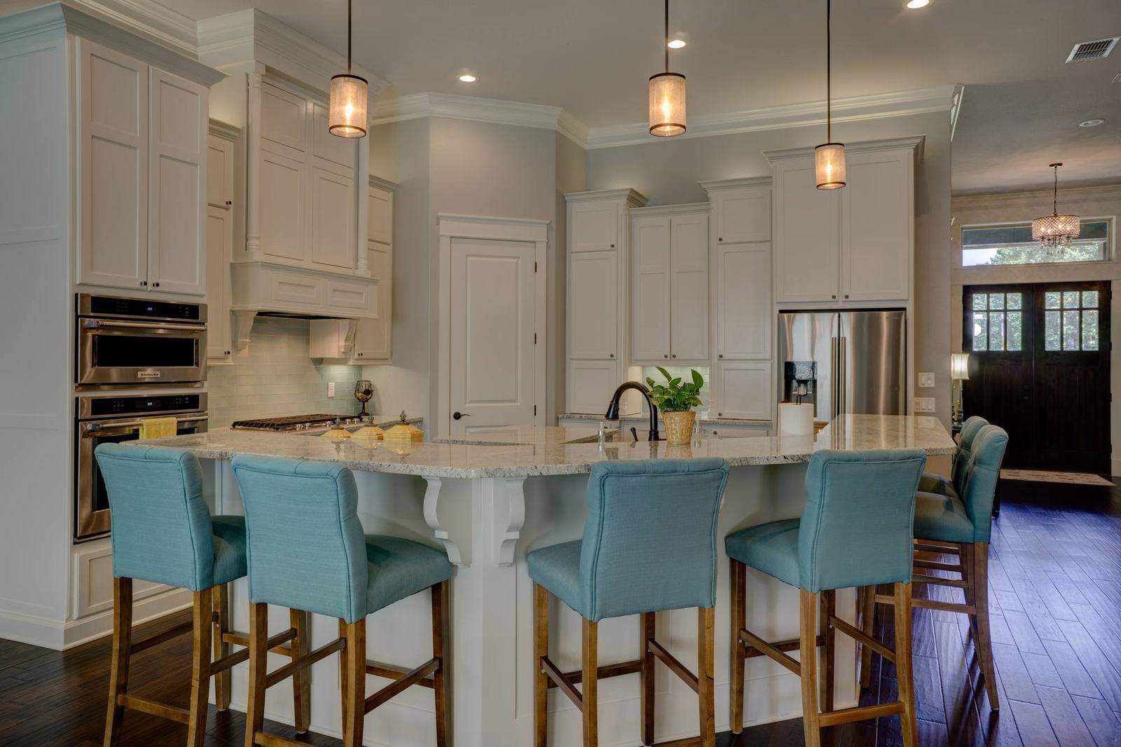 Kitchen with pendant lights and teal stools
