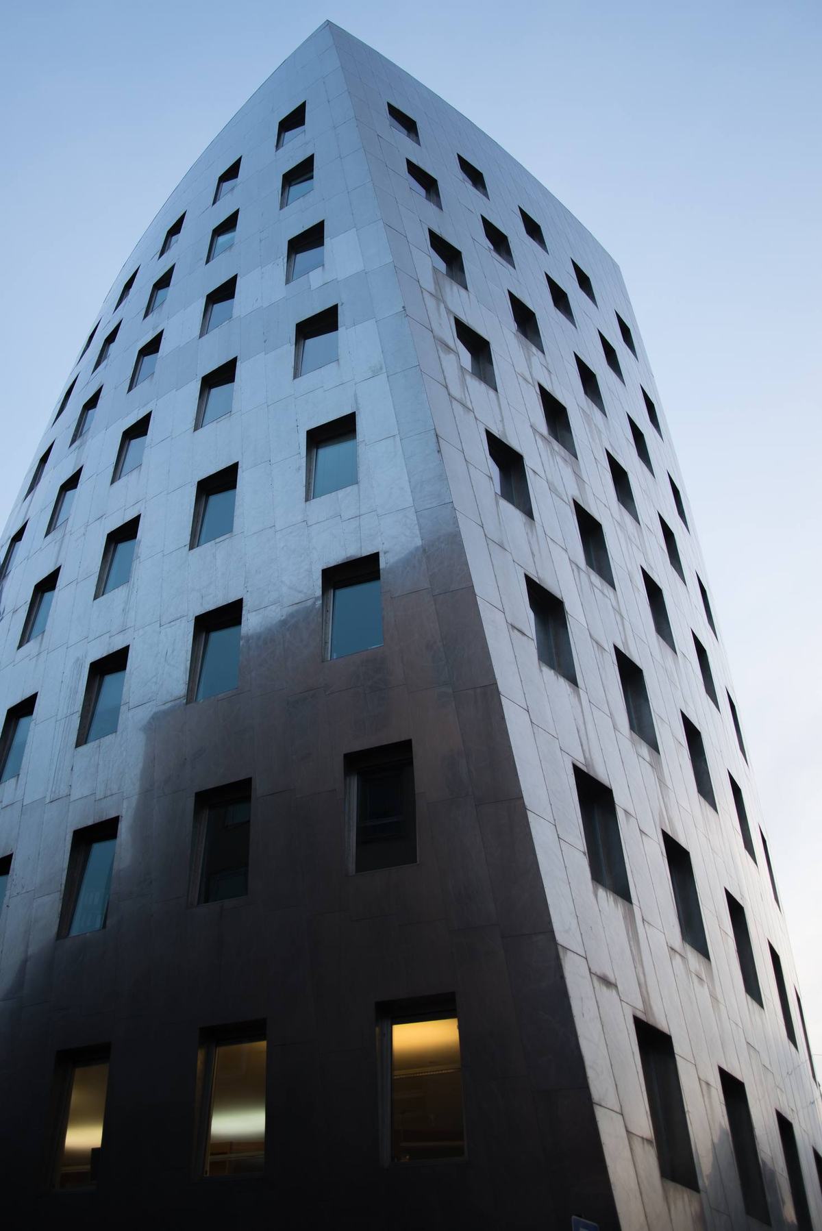 Dark residential tower against a pale sky