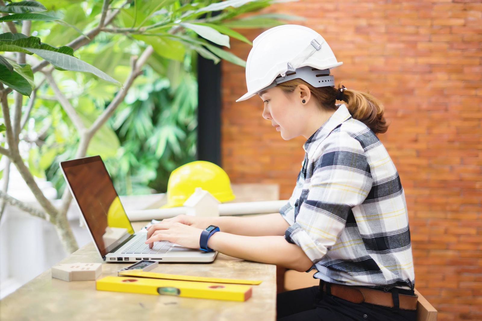 Project manager working at a desk with a hard hat