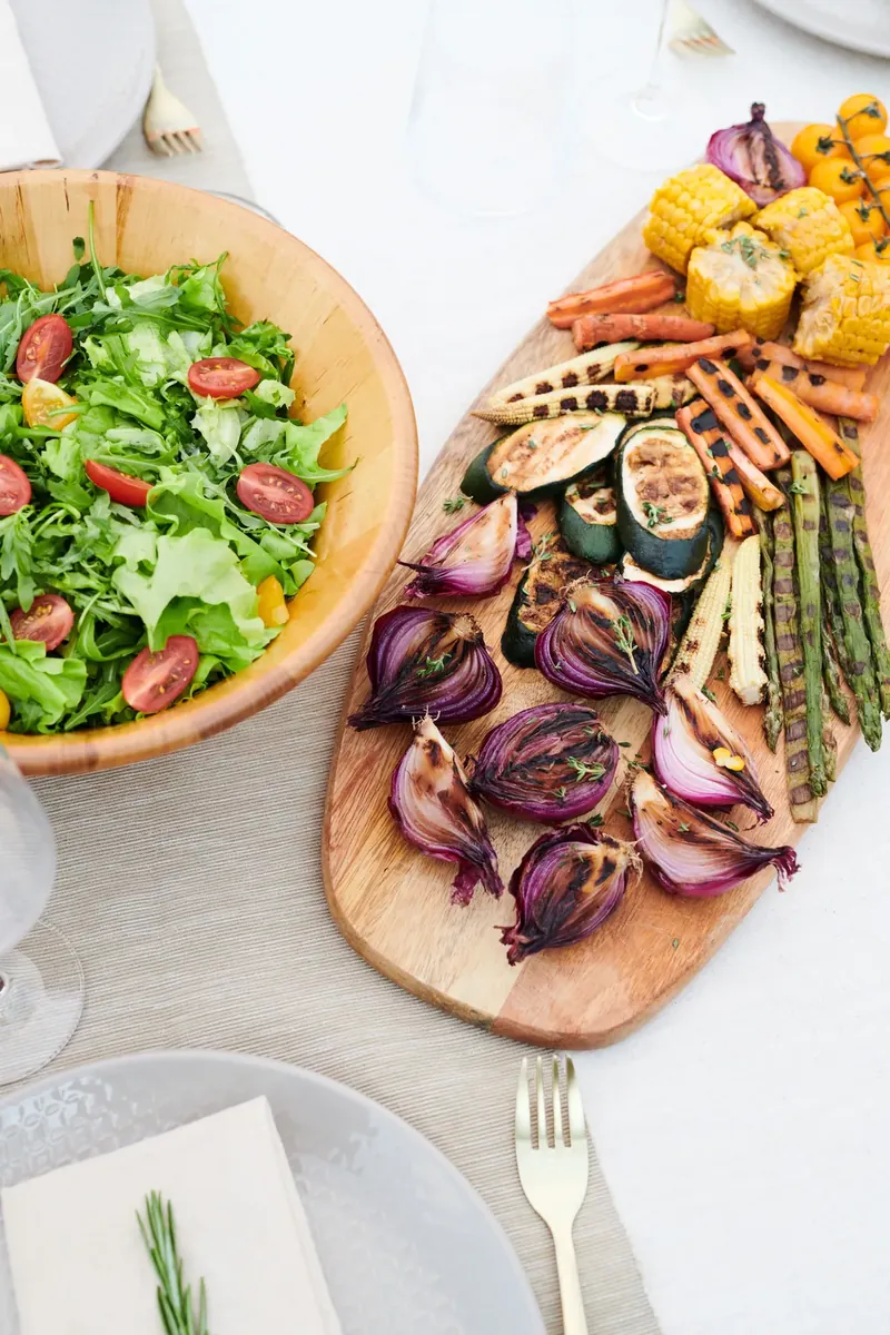 Grilled vegetables and fresh salad on a wooden table