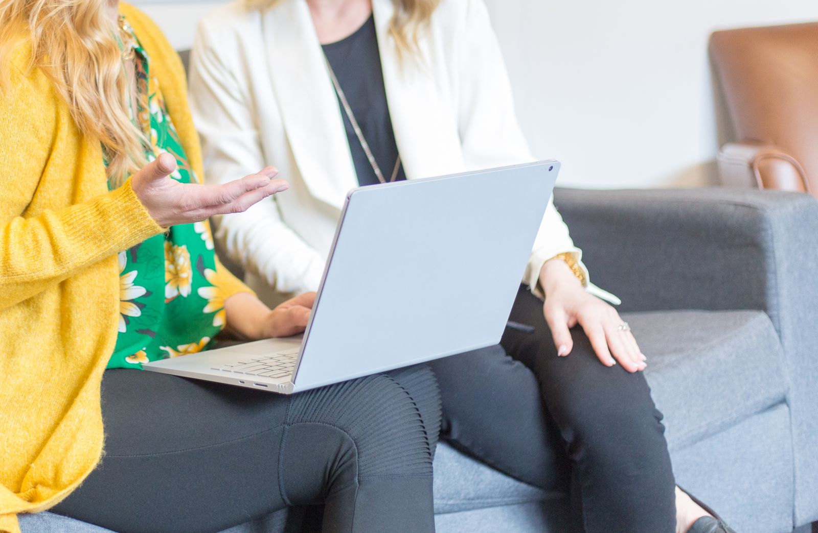 Two colleagues reviewing work together on a laptop