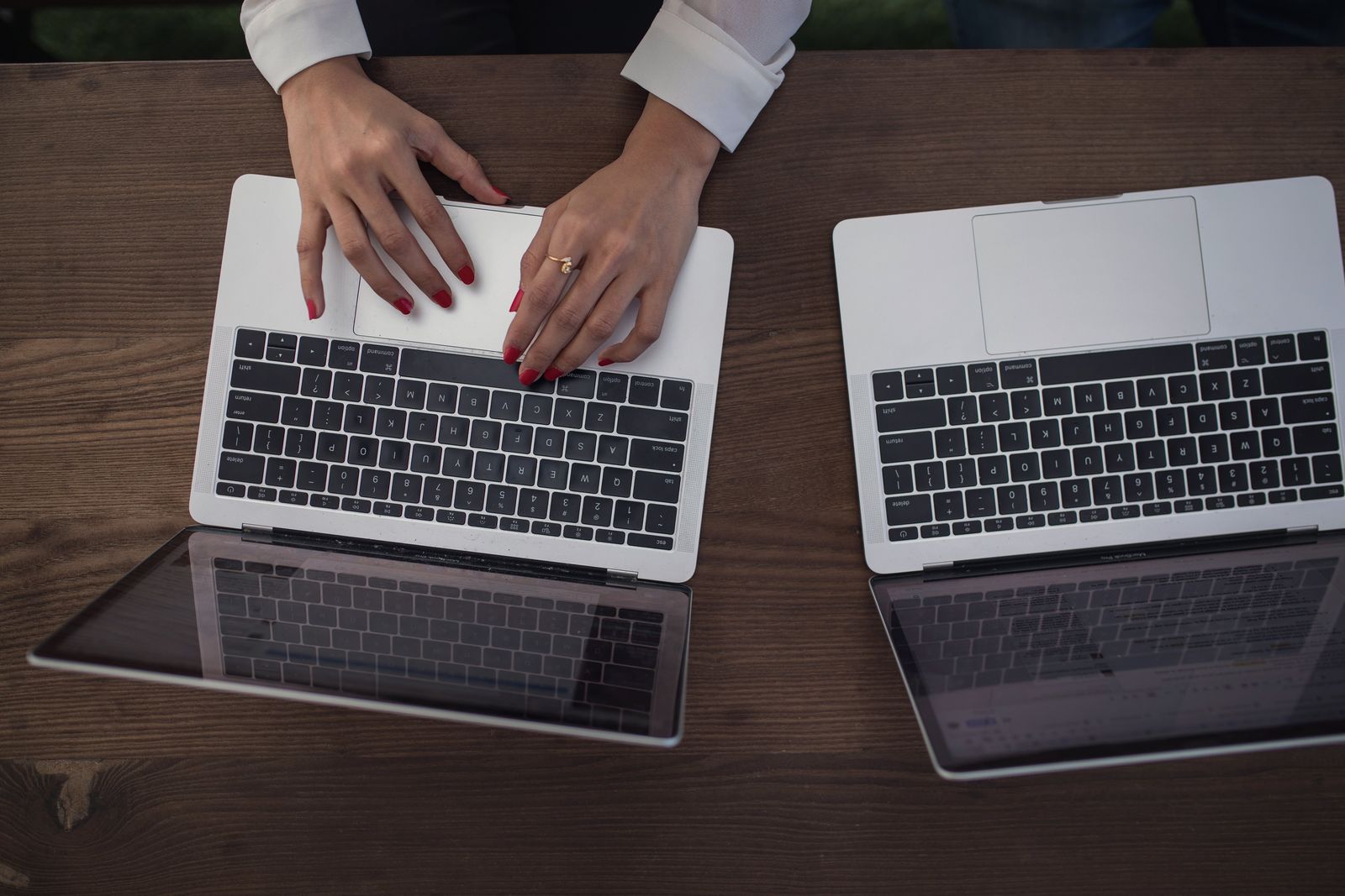 Two people working side by side on laptops