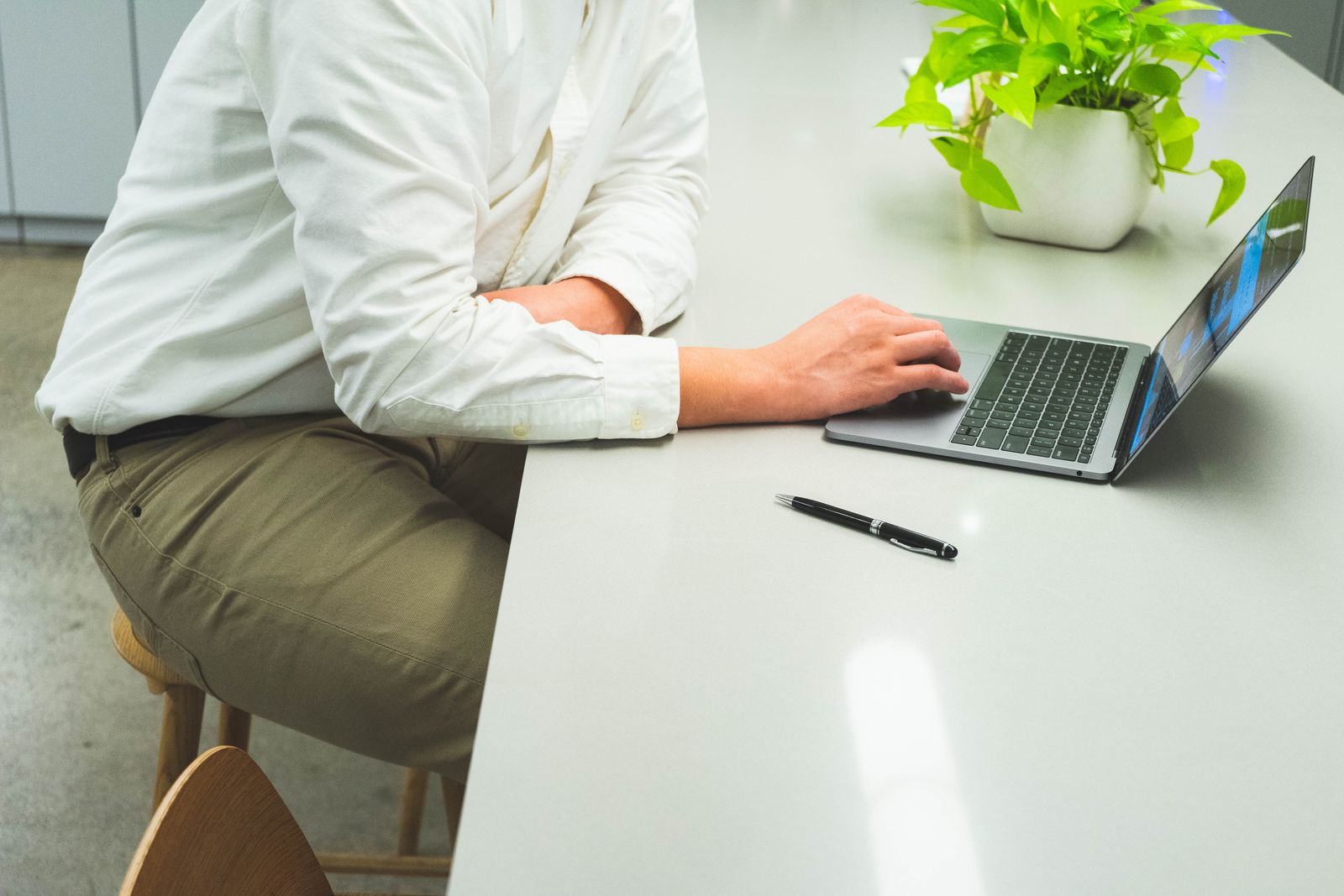 Professional working on a laptop at a bright, minimal desk