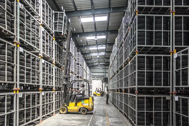 Forklift working between tall storage racks